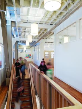 On the second floor, clerestory windows were installed in every classroom wall to allow natural light from outside to come through to the corridors. The wood floors in this space are the same floors that Levi Strauss had his workers install to avoid being laid off during the Great Depression, when jeans manufacturing was down. The staining and scarring on the wood has been preserved so students can see where the production line machinery sat when the building was an active factory.