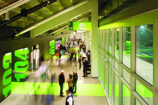 The vivid green lines that start in the parking lot continue through the lobby and the gates to the different sections of the hockey arena. The industrial space—with polished concrete floors and black-painted cinder block walls—is enlivened by supergraphics. Large green numbers mark each door, and large white stylized figures indicate the restrooms.