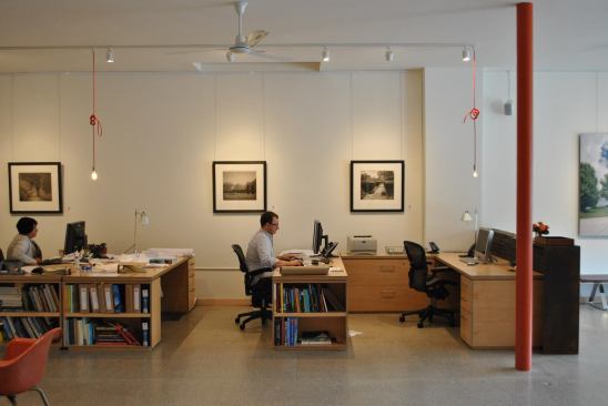 DIY red-cord fixtures add a splash of color, while the firm installed a rotating gallery of for-sale original photographs and prints by local artists.