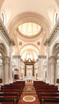 Laid out in a cruciform plan, the chapel interior boasts classical details carved by hand from marble and cast from plaster. A seven-arch colonnade—with Corinthian columns designed by Stroik and an entablature of faux blue marble—runs down either side of the nave, framing relief sculptures depicting the 14 Stations of the Cross in the side aisles. Light filters in through clerestory windows and oculi in the large Brunelleschi-esque dome that precedes the chapel's centerpiece: a 34-foot-tall baldachino inspired by Bernini's baroque masterpiece at St. Peter's in Rome.