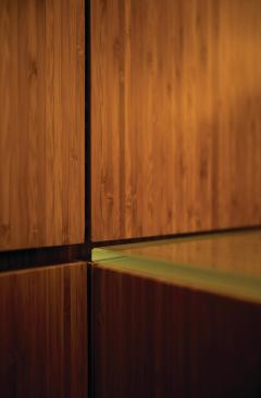 The main retail space is dominated by glass-topped custom bamboo plywood counters and cabinetry.