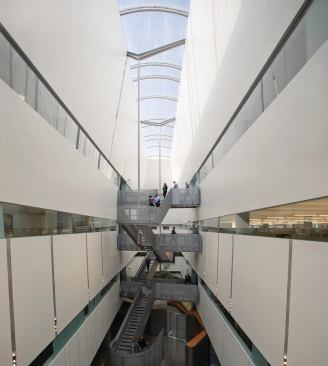 At the center of the building is an 82-foot-high atrium capped with an inflatable membrane skylight that has screen-printed translucent patterning to diffuse the harsh light of the desert sun. Windows into the surrounding offices and laboratories bring daylight into the middle of the floor plates, and an open staircase with large landings allows for both a central circulation point and a spot for spontaneous conversations.