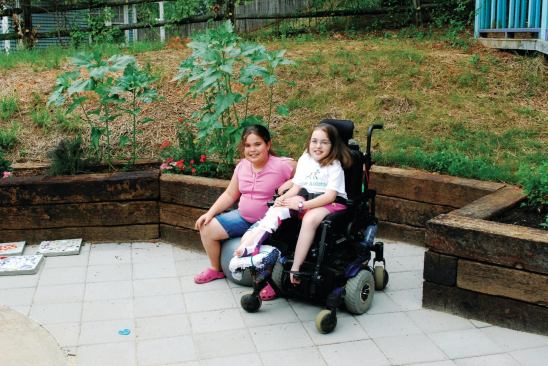 Now Marcella Genut (right, with her younger sister, Isabelle, on the completed patio) is able to garden from her wheelchair.