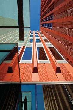 For the University of Michigans Ross School of Business, Kohn Pedersen Fox Associates (KPF) used terra-cotta both as visual punctuation for the glass-and-aluminum curtainwalls and in a rainscreen system for the large planar surfaces. The apparent differences in tile color are due to the fact that some of the tiles have vertical flutes that point to the right, while others have vertical flutes that point to the left.