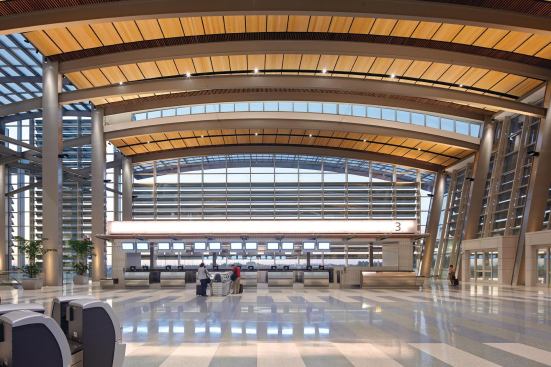 The ticket kiosks in Terminal B are accented with a lightbox header backlit by LEDs. The glow of light serves double duty as a wayfinding device for travelers. Linear pendants with 54W T5HO lamps put light on the ticket counter and 26W compact fluorescent downlights illuminate the baggage belt behind the ticket agents.