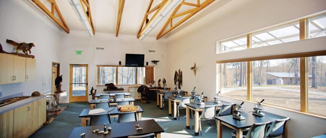 The classroom in the main building is outfitted with microscopes, video equipment, and lab tables for chemistry experiments and water testing. A Polygal awning over the windows helps to mitigate glare from the southwestern sun, and the interior continues the vocabulary of exposed wood structure and white walls found throughout the building.