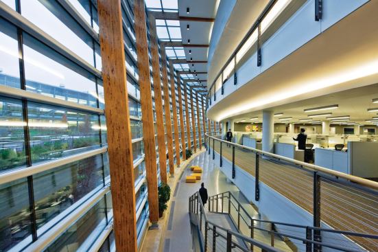 Inside the circulation spine, structural glulam ribs add warmth to the space and help to visually define the limits of the atrium. The second, third, and fourth floors open directly into the atrium, allowing the maximum light transmittance into the open office spaces. Lounge furniture creates break-out spaces on the first floor.