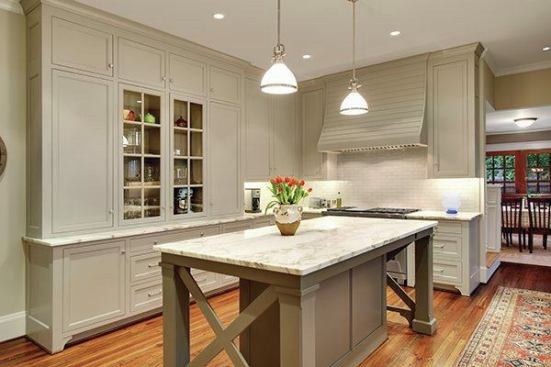 The elegant kitchen palette includes gray/green cabinets, and marble and granite countertops. The floor to ceiling units provide abundant storage.