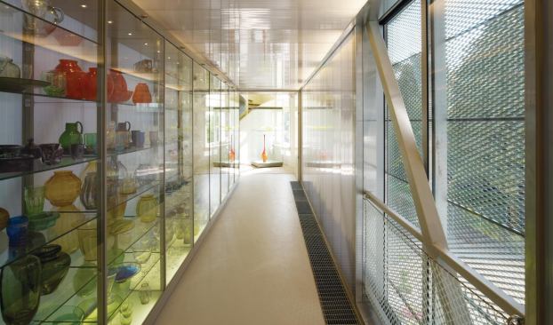 Inside each bridge, interruptions in the polycarbonate walls offer views of the site through the powder-coated aluminum mesh cladding.