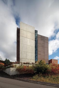 Staircases at either end of the building are enclosed by glass with concrete walls that contribute to the structure and thermal mass of the building.