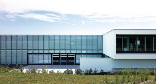A triple-glazed envelope with integrated blinds marks the offices.