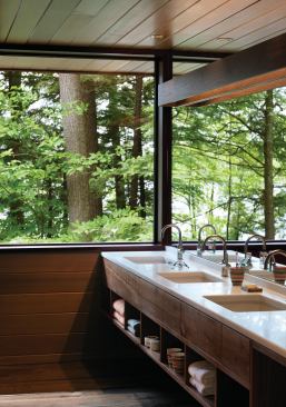 Large windows and cedar siding help emphasize thewoodsy  New Hampshire setting.
