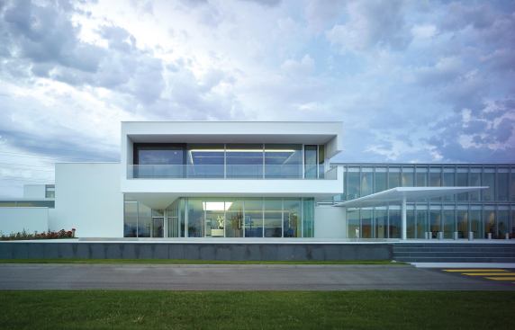Projecting entry volume with lobby and exhibit space on the ground level and a corporate conference room above.