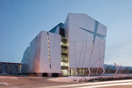 Façade at dusk, with site light fixtures in foreground.