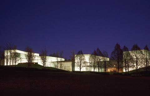 At night the Bloch Building's five “lenses” glow from within forming an illuminated edge to the museum's 22-acre sculpture park.