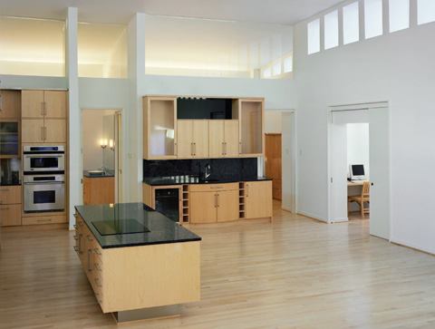 A zone of indirect light—at the upper portion of each wall—gives this loft-like residence an airy feeling. The apartment's open kitchen and living room are the heart of the residence. 