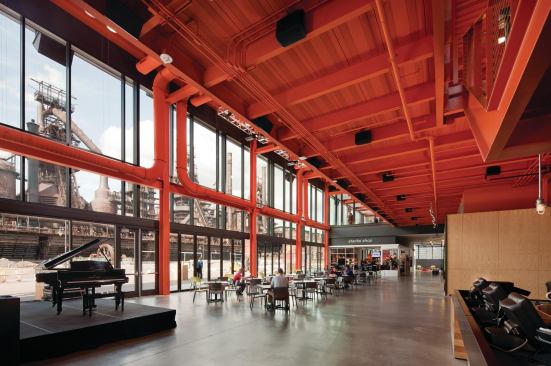 Along the window wall in the lobby is a commons space where visitors browse the gift shop or wait for a showing in one of the building's two movie theaters.