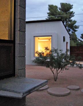 The building's public entry connects directly to the street, bypassing the house completely. But a low window in the living room of the main house alerts the architects to a client's arrival.