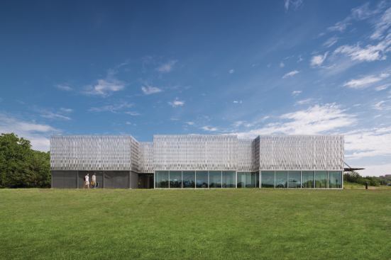 The facility is one continuous structure split into three pods: two enclosed spaces for working on electric vehicles, and an open-air volume.