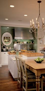 The oval window next  to the stove lets light pass through the interior wall. Placement of the window also marks the cneter line along which the main living spaces -- dining, kitchen and family -- are aligned.  