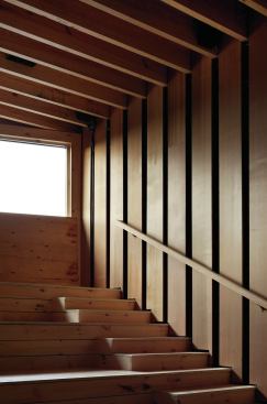 Cedar planks line the interior, including bleacher-style seating at both ends of the dance floor.