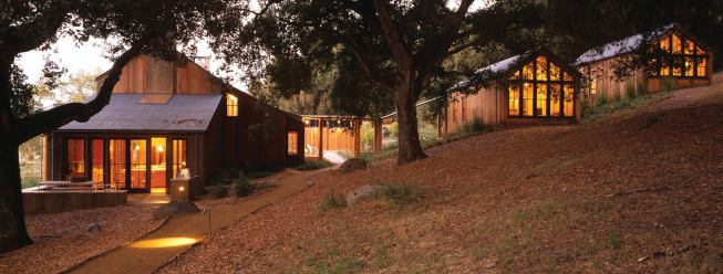 In back, a log arcade connects it to the cabins in the woods.