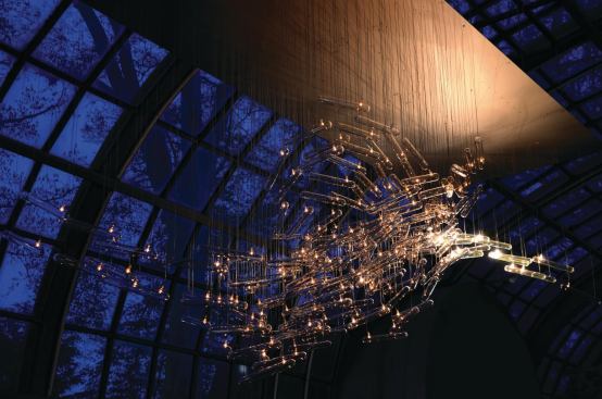Flylight (2007 and 2011), is an interactive light installation made up of as many as 180 hand-blown-glass tubes outfitted with halogen lamps. Inspired by the movement and behavior of a flock of birds, the piece uses ultrasonic sensors to measure the distance between the viewer and the installation. The art piece then responds to the proximity of the viewers by lighting up. Each glass module measures approximately 11 inches long by 1-1/2 inches in diameter, and overall installation dimensions start at 6-1/2 feet tall by 10 feet wide.
