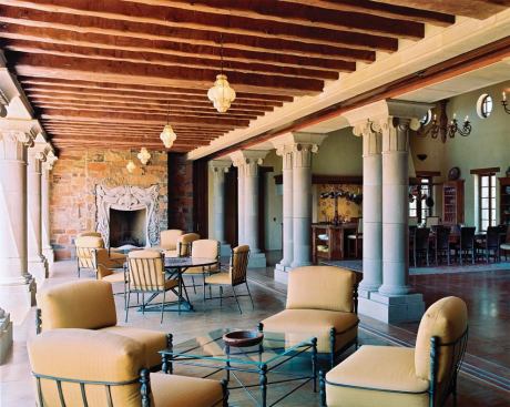 A wall of lift-and-slide doors opens the great room colonnade to a covered terrace with an outdoor fireplace.

