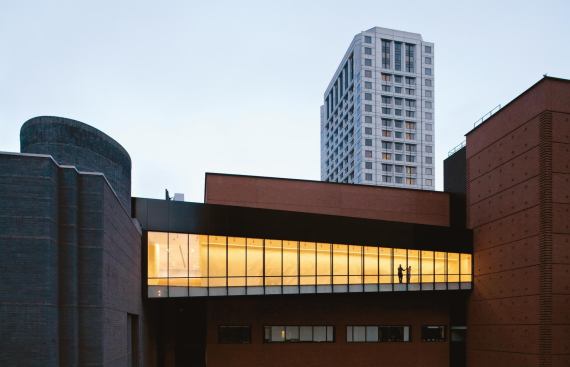 The walkway connects the brick-colored, Mario Botta–designed museum building to the new sculpture garden atop the adjacent parking garage. Through the glass wall, one can see into the overlook, an extension of existing galleries that looks out on pieces installed in the garden’s open-air exhibition area.