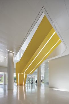 Yellow stairways, such as this one leading from the ground-floor entrance to the main lobby, incorporate light fixtures on their undersides.