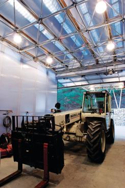 Tractor in storage area with translucent solar panels visible overhead