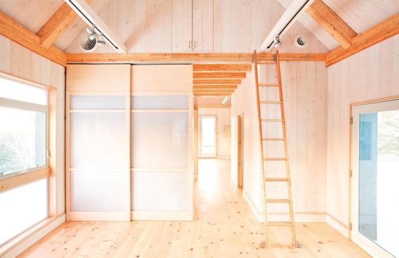 Moveable wall partitions are used to define the spaces in this 640-square-foot model. A rolling ladder provides access to the loft area.