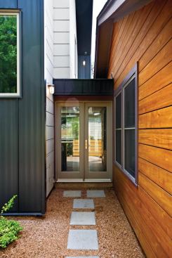 A slight separation between the existing house and new addition allows each volume to maintain a distinct identity. Twin sets of double glass doors enclose that in-between space and bring light into the center of the house.