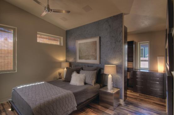 The master bedroom headboard becomes a wall for privacy in the open master bath. Having the two spaces flow into one another is just one technique used to make this compact floor plan feel spacious and airy. 