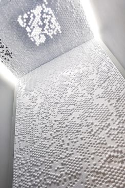 The patterning of the panels was customized to the needs of this particular bathroom application. The ceiling fan vent and skylight, for example, are accommodated by perforated panels—an adaptive characteristic that piqued the jury's interest.