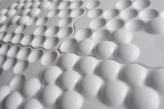 All panels are joined via a serpentine seam that weaves between the dots on the adjacent tiles so as not to disrupt the overall effect of the vacuum-formed surface

