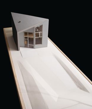 Developed by the design team as a simple folded surface, the form of the R-House can be seen as a (literal) twist on the traditional gabled roof: The architects set the gable askew and tucked small front and back porches beneath it. Energy-efficient features are integrated into the house's design. Ample windows with triple-pane, double-low-E glazing on the south face optimize solar gain, while external shading and an operable skylight aid passive cooling. Heating demand is met entirely by warming the required fresh air supply. The house's compact form enhances its energy performance, which meets Germany's stringent Passivhaus standard.