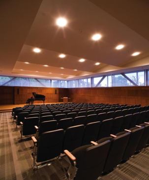Equipped for lectures, film screenings, and musical performances, the lower-level auditorium features a baffled ceiling, cherry paneling, and large clerestories — the latter made possible by the ground plane that slopes away from the building.