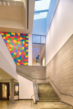 An open, skylit stair descends from the winter garden to lower-level offices, two new classrooms, and a 180-seat auditorium.