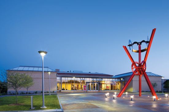 The new north addition is a glass-enclosed lobby space that serves as the museum's main entrance. Charlotte, N.C.–based artist Tom Schulz was commissioned to create a custom concrete finish for the plaza, which involved staining large square sections and scoring the surface.