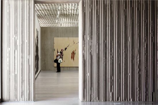 The regularity of the ceiling’s perforation patterns offers a texture complementary to the museum’s variable-width-board-formed concrete walls.