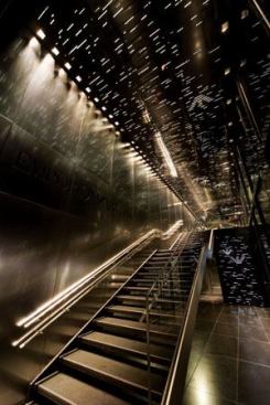 The design element from the Emporio Armani retail areas?black stainless-steel panels with laser-cut slots backlit with fluorescent lamps?is carried through tothe common stair of the Tokyo subway stop that sits directly beneath the Armani store location. 