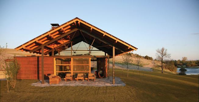 Sliding doors of weathering steel can be closed over the glass walls on cold nights and during inclement weather.

