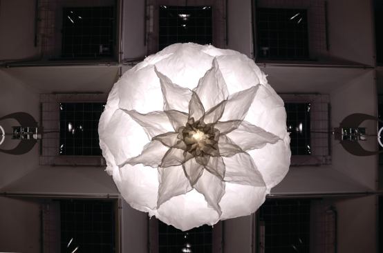 As each light that is part of Shylight descends, the springs push out the silk shade," blooming" like a flower openings its petals. Then, as the light retracts and the springs pull in, the silk folds back up. 