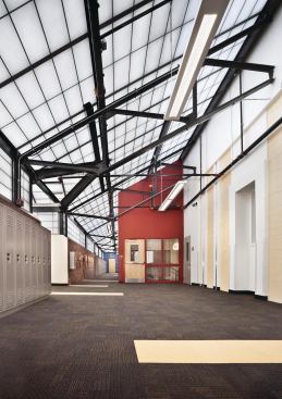 Now, the glass has been replaced with translucent panels, and an inserted slab creates a third floor of classrooms with a wide enough hallway to serve as an informal student gathering space.