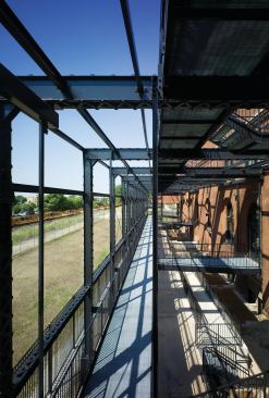 On the south side of the building, a massive system of catwalks was put in place to allow for a code-required third point of access to the fire department. Doubling as a shading device, the structure hangs off the original building frame. Doors from each classroom open onto the walkways to provide egress.