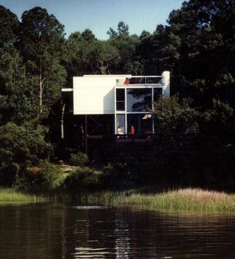 Two-story-high windows in the living room of the Wainwright Beach House allow summer winds to bring the sounds and scents of the ocean into the house while framing views of water and sky.