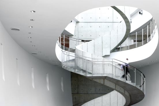 Underneath it, the spiral stair in the atrium, inspired by strands of DNA, is supported only at the bottom and at the third level.