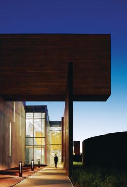 Fully glazed sections between the more solid concrete and Cor-Ten steel allow passersby to see the activity within.