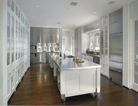 A perpendicular singlestory volume houses the informal living spaces, including a spare but elegant kitchen.
